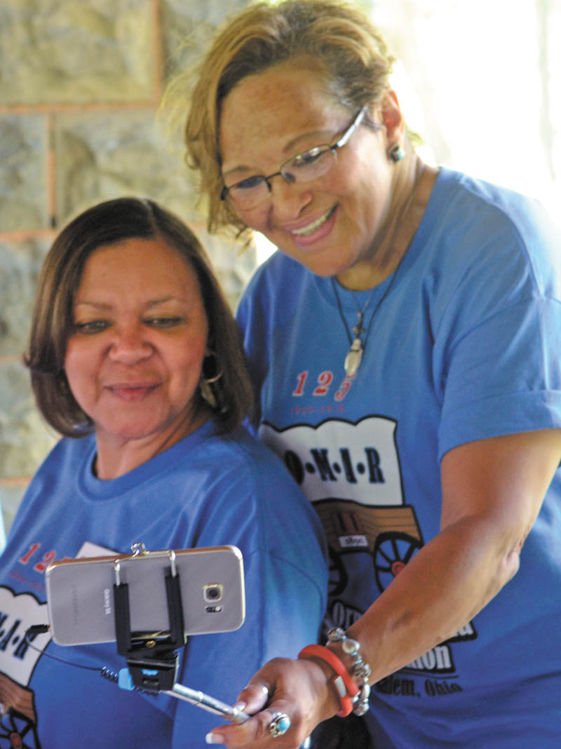 Katie Rickman | The Vindicator: Vicki Adams-Hill of Toledo, above right, commemorates the moment with her relative Terri Whipple of Youngstown by taking their picture together at the family reunion. 