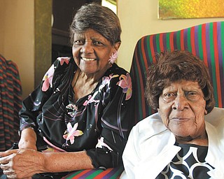 Mary Johnson, 103, right, is seated with her younger sister, Jessie Washington, 101, at Johnson’s Youngstown home. The two centenarian sisters, who recently celebrated their birthdays together, are the sole survivors of 12 siblings. WILLIAM D. LEWIS | THE VINDICATOR