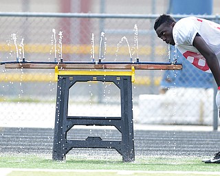 AUSTINTOWN, OHIO - AUGUST 11, 2015: Earl Scott #28 of Fitch gets a drink from the water trough during a preseason practice at Fitch High School. DAVID DERMER | THE VINDICATOR