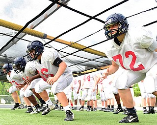 AUSTINTOWN, OHIO - AUGUST 11, 2015: Andrew D'Amico #72 Joel Sandy #66, Nate Armstrong #74 and Aaron Cross #73 of Fitch fire off the football while running under the chute during a defensive line drill Tuesday morning during a preseason practice at Fitch High School. DAVID DERMER | THE VINDICATOR