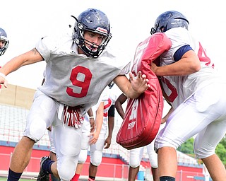 AUSTINTOWN, OHIO - AUGUST 11, 2015:Shane Kunovich #9 of Fitch rips though a bag being held by Tommy Ellsmore #40 during a linebackers drill Tuesday morning during a preseason practice at Fitch High School. DAVID DERMER | THE VINDICATOR