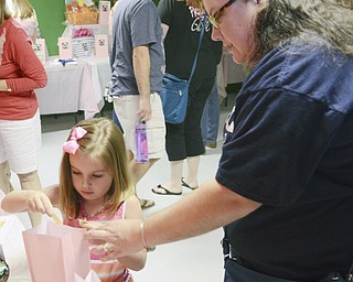Katie Rickman | The Vindicator.Karenna Miller 5 of Mineral Ridge places a ticket in a bag during a raffle with her aunt Lisa Herttua (OKAY) of Hubbard prior to the ceremony of foster dogs Izzy and Bear at The Learning Dog August 22, 2015.