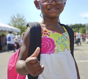 Katie Rickman | The Vindicator.Olivia Reynolds 3 of Youngstown gives a thumbs up as she smiles after trying on her new pink backpack after the community wide back-to-school backpack giveaway at the Covelli Centre August 24, 2015.