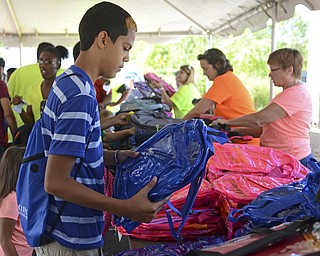 Katie Rickman | The Vindicator.Arnaldo Oliveras 11 looks through backpacks, Oliveras recently relocated to Youngstown with his family from Philadelphia, Pennsylvania and he is unsure of where he will go to school.