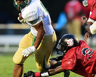 YOUNGSTOWN, OHIO - AUGUST 28, 2015: Running back Deinn Edwards #8 of Ursuline runs the football while Jonathan Gregory #3 of East attempts to tackle him during the 2nd half of a game Friday night at Rayen Stadium. DAVID DERMER | THE VINDICATOR