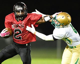 YOUNGSTOWN, OHIO - AUGUST 28, 2015: Running back Mike Lawrence #2 of East stiff arms Anthony Protopapa #4 of Ursuline during the 2nd half of a game Friday night at Rayen Stadium. DAVID DERMER | THE VINDICATOR