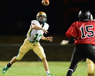 YOUNGSTOWN, OHIO - AUGUST 28, 2015: Quarterback Jared Fabry #13 of Ursuline throws a pass while rolling out during the 2nd half of a game Friday night at Rayen Stadium. DAVID DERMER | THE VINDICATOR..Mike Stevens #15 of East pictured.