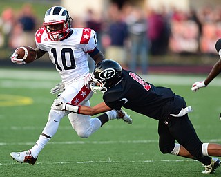 GIRARD, OHIO - AUGUST 27, 2015: Steven Mintz #10 of Niles runs with the football while being wrapped up by Anthony Backus #8 of Girard during the 1st half of their football game Thursday night at Arrowhead Stadium. DAVID DERMER | THE VINDICATOR