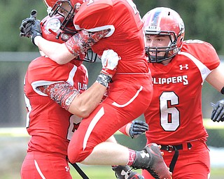Jeff Lange | The Vindicator  AUGUST 27, 2014 - Clippers' Tanner Smith (7) leaps into the arms of teammate Dalton Miller after Miller's 52 yard touchdown reception to make the score 6-0 over the Blue Devils in the first quarter of their Thursday-night game at Firestone Stadium in Columbiana. Colombian's Jacob Ward (6) looks on from behind.