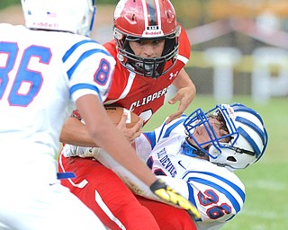Jeff Lange | The Vindicator  AUGUST 27, 2014 - Columbiana's Jacob Ward (center) is brought down by Western Reserve's Kyle Hilles (36) in the first quarter of their game, Thursday night in Columbiana.