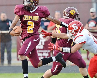 Jeff Lange | The Vindicator  AUGUST 28, 2015 - Liberty's JaShaun Whitman (2) sheds Struthers' defender Jose Perez as he rushes for a small gain in the first half of their game, Friday night in Liberty.