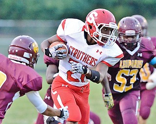 Jeff Lange | The Vindicator  AUGUST 28, 2015 - Struthers' Regal Reese (center) rushes for yards in between the defense of Liberty's Capone Haywood (left) and John Spivey in the first half of their game, Friday night in Liberty.