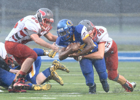 Jeff Lange | The Vindicator  AUGUST 29, 2015 - Valley Christian's Berchindle Foster (25) is tackled from behind by Labrae's Dalton Stout (59) and Conner Wilson (66) after a small gain during second quarter action of Saturday night's game in Poland.