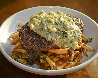 The "Castle Meat & Potatoes" which is ground chuck, beer cheese, roasted tomato, pickle, shaved red onion, baby greens and is served with fries at The Common Wealth  in New Castle, Pennsylvania.