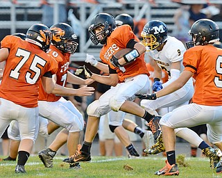 Jeff Lange | The Vindicator  SEPTEMBER 4, 2015 - Tigers' Jake Ford (center) hops through a host of Springfield and McDonald players, late in the second quarter of Friday night's game in Springfield.