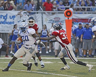Katie Rickman | The Vindicator.Girard's Jamil Bannister  reaches out and tries to stop Hubbard's Brandon Rios #20 during the first half of the game at Arrowhead Stadium Friday Sept. 4, 2015.