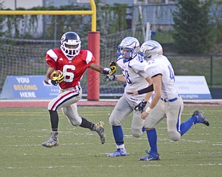 Katie Rickman | The Vindicator.Dontae Snyder #6 holds off Hubbard's Jacob Nail #58 and Cody Smith #42 during the first half of the game on Friday Sept. 4, 2015.