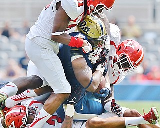 Jeff Lange | The Vindicator  SEPTEMBER 5, 2015 - Pitt running back Chris James (center) is tackled by a host of YSU defenders LeRoy Alexander (bottom) and David Rivers III (31) in the first half of Saturday's game at Heinz Field.