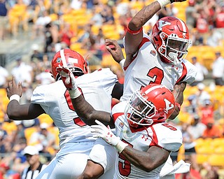 Jeff Lange | The Vindicator  SEPTEMBER 5, 2015 - YSU's Avery Moss (left), Demond Hymes (5) and LeRoy Alexander (3) celebrate in the end zone after a touchdown late in the first half against Pitt, Saturday afternoon at Heinz Field.