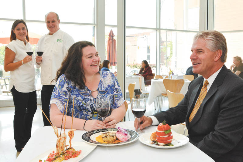 SPECIAL TO THE VINDICATOR
Promoting the Society of Adventurous Diners are Katie Merrill, seated, S.A.D. coordinator, and Mark Wenick, Youngstown Symphony Society board member, while in background, Nora Chrystal, YSS board member, and Jeffrey Chrystal, Overture executive chef, sample wine. S.A.D. will offer unique dining experiences to promote Overture.