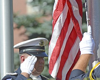 Katie Rickman | The Vindicator.Shawn Murray with the Youngstown Fire Department Honor Guard salutes the flag as it is lowered to exchange it for the traditional flag ceremony during the Mahoning Valley 9-11 Memorial Ceremony at the 9-11 Memorial Park on Raccoon Road on September 11, 2015.