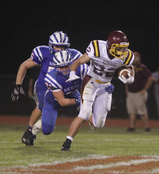       .         ROBERT  K. YOSAY | THE VINDICATOR..Raiders #22   Ethan Dominquez tries to elude 321 Blue Devil Ed Smith and #56  T J Henry..South Range at Western Reserve ...-30-