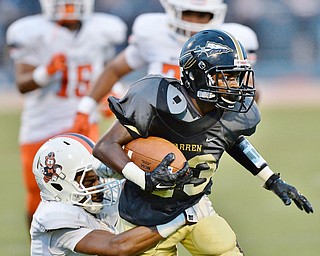 Jeff Lange | The Vindicator  SEPTEMBER 11, 2015 - Warren Harding's Juvar King (right) rushes as he's tackled at the waist by Massillon's Anthony Ballard during second quarter of their game in Warren on Friday night.