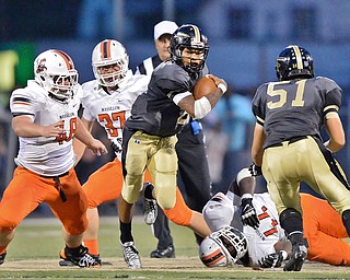 Jeff Lange | The Vindicator  SEPTEMBER 11, 2015 - Warren Harding's quarterback Lynn Bowden (center) breaks away from Massillon defenders Dakota Dunwiddle (48), Neil Huth (37) and Malcolm Robinson (44) during second quarter action of Friday night's game in Warren.