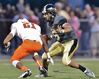 Jeff Lange | The Vindicator  SEPTEMBER 11, 2015 - Warren G. Harding quarterback Lynn Bowden (6) rushes past Massillon's Anthony Ballard (21) late in the second quarter of Friday night's game in Warren.