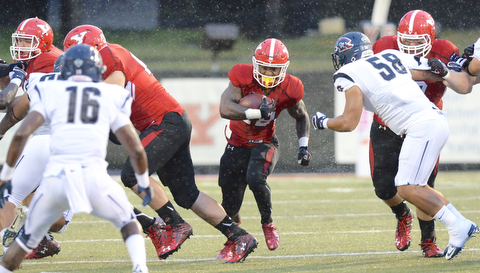 Jeff Lange | The Vindicator  SEPTEMBER 12, 2015 - YSU's Tre'von Williams (center) breaks through the line during first quarter action of the Penguins' Saturday-night game against RMU at Stambaugh Stadium.