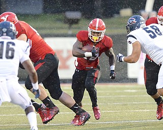 Jeff Lange | The Vindicator  SEPTEMBER 12, 2015 - YSU's Tre'von Williams (center) breaks through the line during first quarter action of the Penguins' Saturday-night game against RMU at Stambaugh Stadium.