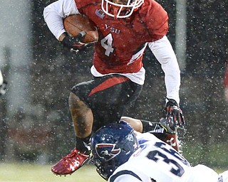Jeff Lange | The Vindicator  SEPTEMBER 12, 2015 - YSU's Andre Stubbs (4) jumps over the tackle of Robert Morris' Cole Blake (36) in the first half of their game in Youngstown, Saturday evening.