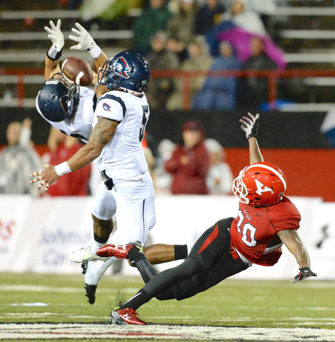 Jeff Lange | The Vindicator  SEPTEMBER 12, 2015 - YSU wide receiver Andrew Williams (right) trips to the ground as the pass is broken up by RMU's Andy Smigiera and Marcelis Branch (5) late in the second quarter of Saturday night's game in the rain at Stambaugh Stadium.