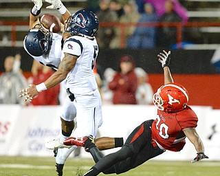Jeff Lange | The Vindicator  SEPTEMBER 12, 2015 - YSU wide receiver Andrew Williams (right) trips to the ground as the pass is broken up by RMU's Andy Smigiera and Marcelis Branch (5) late in the second quarter of Saturday night's game in the rain at Stambaugh Stadium.