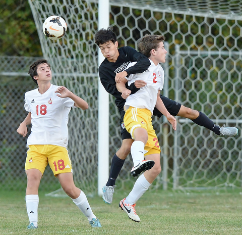 Jeff Lange | The Vindicator  SEPTEMBER 15, 2015 - CVCA's Daniel Chung (center) heads the ball past Mooney players Benny Trgovcich (18) and Evan Leek (2) during first half action of Tuesday night's game in Struthers.