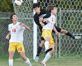 Jeff Lange | The Vindicator  SEPTEMBER 15, 2015 - CVCA's Daniel Chung (center) heads the ball past Mooney players Benny Trgovcich (18) and Evan Leek (2) during first half action of Tuesday night's game in Struthers.