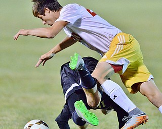 Jeff Lange | The Vindicator  SEPTEMBER 15, 2015 - Cardinal Mooney junior Christopher Perry (top) topples over CVCA sophomore Collin Gaines as they battle for the ball early in the second half of their game, Tuesday night in Struthers.