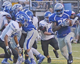 Katie Rickman | The Vindicator.Hubbard's Brandon Rios (#20) on right rushes past Lakeview's Mitchell Franco (#62) and Jatise Garrison (#20) to score the first points for Hubbard during the first half of the game at Hubbard on Friday, September 18, 2015.