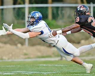 Jeff Lange | The Vindicator  SEPTEMBER 18, 2015 - Poland wide receiver Tyler Smith (12) attempts to make a diving catch as Howland cornerback Shawn Carr attempts to tackle him from behind during first quarter action of their matchup at Howland High School on Friday night.