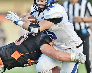 Jeff Lange | The Vindicator  SEPTEMBER 18, 2015 - Poland quarterback Nick Buccieri (15) runs for a small gain as Howland's Tommy Carnifax tackles him during first quarter action of their game Friday night in Howland.
