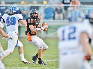Jeff Lange | The Vindicator  SEPTEMBER 18, 2015 - Howland quarterback Victor Williams (20) looks downfield for an open receiver through a number of Poland defenders late in the first half of their matchup in Howland Friday night.