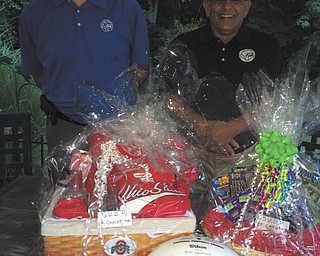 SPECIAL TO THE VINDICATOR
Brian Antal, left, president of St. Vincent de Paul Society of Mahoning Valley, and Dennis Mamone, chairman of the steak fry fundraiser set for Saturday at St. Christine Church social hall in Youngstown, show examples of baskets for the event’s auction.