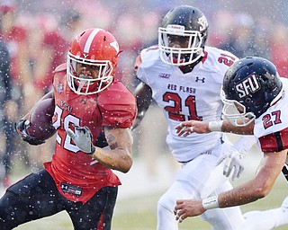 Jeff Lange | The Vindicator  SEPTEMBER 19, 2015 - YSU's Jody Webb (left) rushes past SFU defenders Delondo Boyd (21) and Jalen Wells (27) late in the second quarter of Saturday's game in Youngstown.
