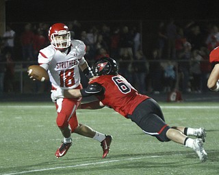       .         ROBERT  K. YOSAY | THE VINDICATOR..Struthers QB #18 A J Musolino  is caught behind the line by Canfield #60 Daniel Kapalko   as AJ tried to unload a pass it was incomplete during second half action..struthers at canfied. -30-