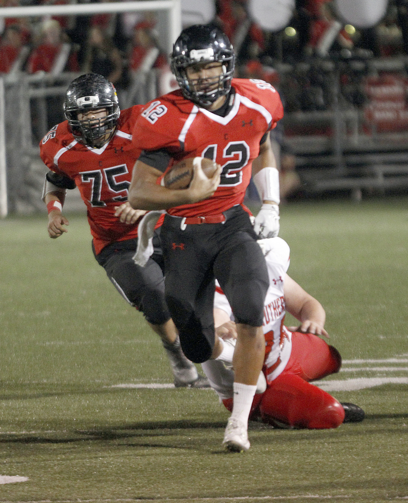       .         ROBERT  K. YOSAY | THE VINDICATOR..Canfields QB #12   Kato Kim breaks for a big gain as Strutehrs #24 Anthony Malone tries to grab with one hand #75 Canfield  Carmin Zena..struthers at canfied. -30-