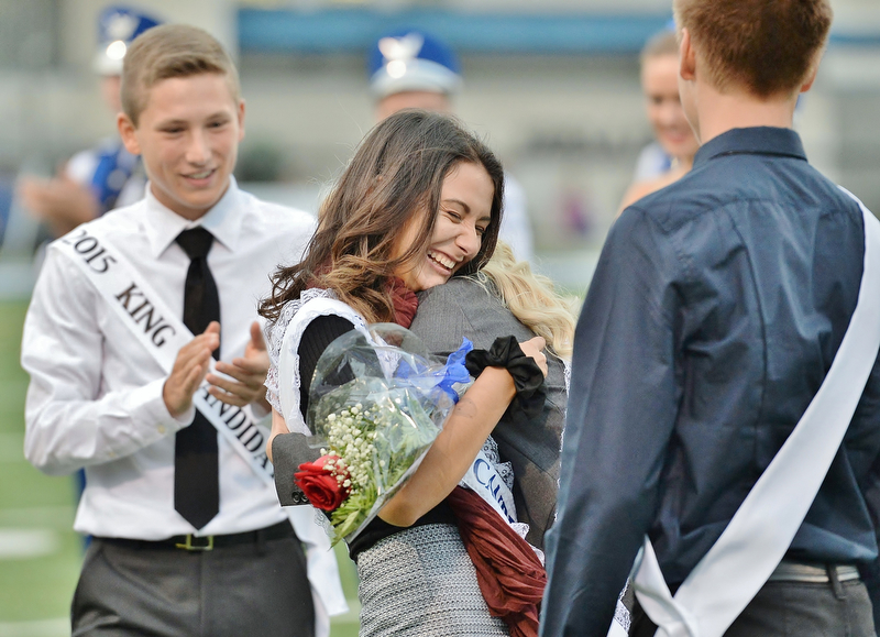 Jeff Lange | The Vindicator  SEPTEMBER 25, 2015 - Hubbard senior Lauren Cooper (center) embraces last year's homecoming queen in celebration of being crowned Hubbard's 2015 homecoming queen prior to the start of Friday evening's game against the Howland Tigers.