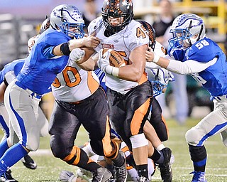 Jeff Lange | The Vindicator  SEPTEMBER 25, 2015 - Howland's Tommy Carnifax (45) runs for yards as a pair of Hubbard defenders brings him down during first half action at Hubbard High School Friday night.
