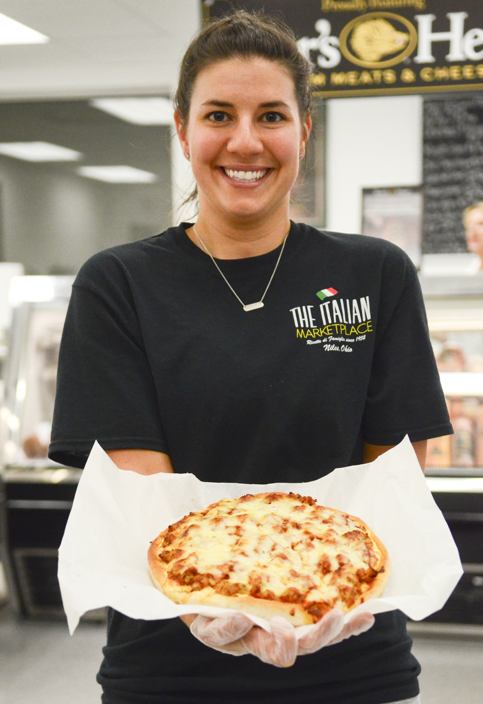 Katie Rickman | The Vindicator Daughter-in-law Allie Rosati, assistant manager, shows a pizza that is one of the top sellers at the store.