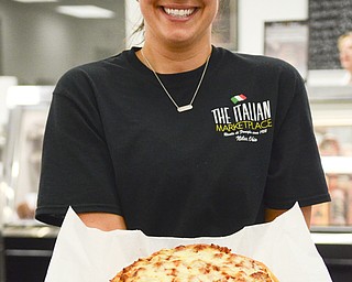 Katie Rickman | The Vindicator Daughter-in-law Allie Rosati, assistant manager, shows a pizza that is one of the top sellers at the store.