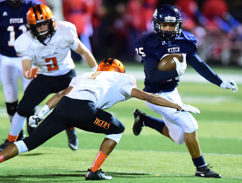 AUSTINTOWN, OHIO - OCTOBER 2, 2015: Randy Smith #25 of Fitch runs the football away from Jeff Kock #1 of Massillon during their game Friday night at Fitch Falcons Stadium. DAVID DERMER | THE VINDICATOR